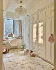 two dogs are sitting on the floor in front of an open closet with white furniture