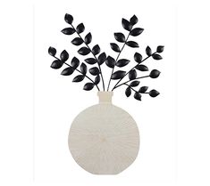 a vase filled with black leaves on top of a white table