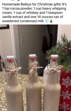 three empty bottles sitting on top of a counter next to a red bag and christmas tree