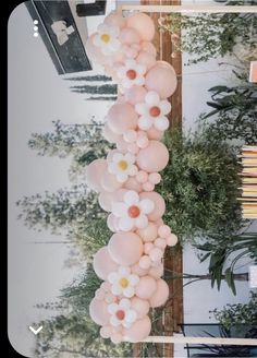 some balloons are hanging from a pole in the middle of a room filled with plants