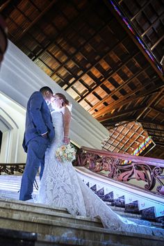 a bride and groom kissing on the stairs