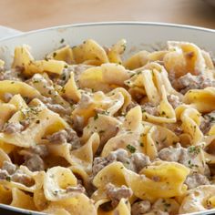 a bowl filled with pasta and meat on top of a table