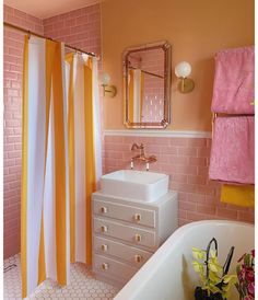 a bathroom with pink, yellow and white decor on the shower curtain next to the bathtub