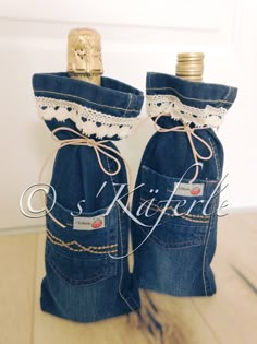 two blue jeans with lace on them are sitting in front of a white wall and there is a bottle that has been placed inside