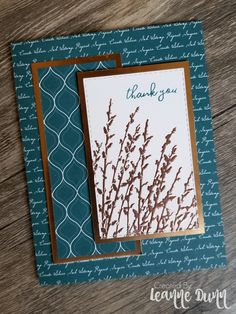 a close up of a thank you card on a wooden table with blue and white background