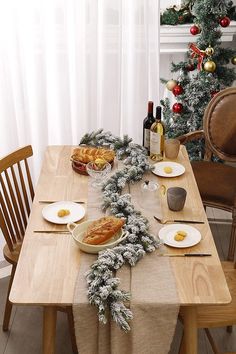 the table is set for christmas dinner with bread and wine