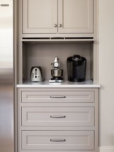 a kitchen with white cupboards and appliances on top of it's counter tops