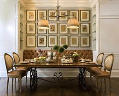 a dining room table with chairs and pictures on the wall above it, along with place settings for four