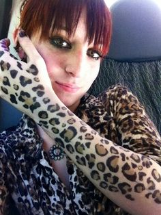 a woman with red hair wearing leopard print gloves