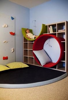 a child's bedroom with climbing walls and a bed in the shape of a ball