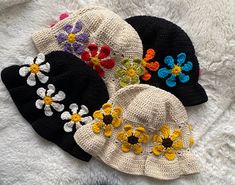 three hats with flowers are laying on a blanket