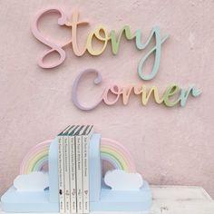 a stack of books sitting on top of a table next to a sign that says story corner