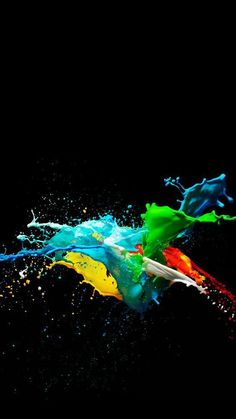 colorful paint splashing in the air on a black background