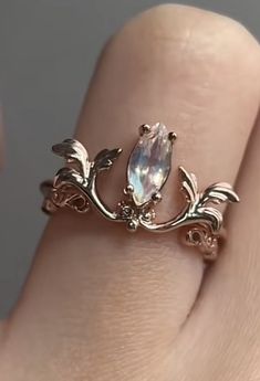 a close up of a person's hand wearing a ring with an oval stone