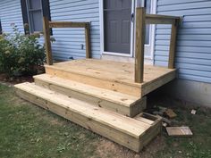 a wooden deck with planters on it in front of a house