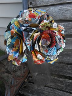 a paper flower sitting on top of a wooden bench