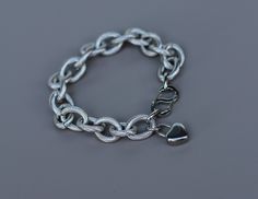 Made from high-quality steel fittings, this chain is very durable and heavy. Each link of the chain has a texture that adds to the longevity of the jewelry. The bracelet features a two-sided, easy-to-use S-shaped clasp and includes a heart-shaped lock charm. The total length of the bracelet is 8 1/4 inches. I can shorten it by removing links; please contact me in advance for adjustments Silver Cable Chain Metal Bracelets, Modern Rolo Chain Bracelet, Metal Charm Bracelet With Cable Chain Links, Modern Silver Rolo Chain Bracelet, Modern Rolo Chain Link Bracelet, Metal Link Bracelets With Rolo Chain, Silver Cable Chain Bracelet, Minimalist Metal Cable Chain Bracelet, Silver Stainless Steel Bracelet With Cable Chain