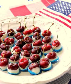 small cherries are arranged on a plate with an american flag in the back ground