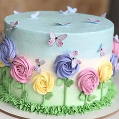 a multicolored cake decorated with flowers and butterflies