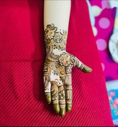 a woman's hand with henna tattoos on it