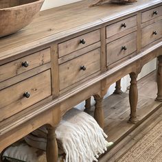 a large wooden dresser sitting on top of a hard wood floor next to a bowl