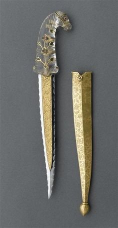 two knives with gold handles are shown next to each other on a gray surface,