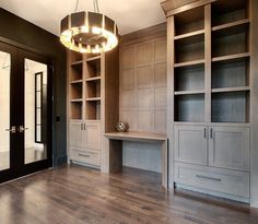 an empty room with wooden floors and built in cabinets