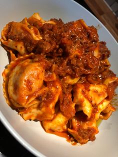 a white plate topped with pasta covered in sauce