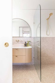 a bathroom with a sink, mirror and shower