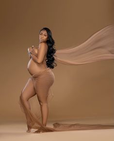 an image of a woman with long hair and no bra posing in front of a brown background