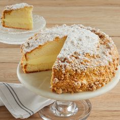 a cake sitting on top of a white plate next to a piece of cake covered in powdered sugar