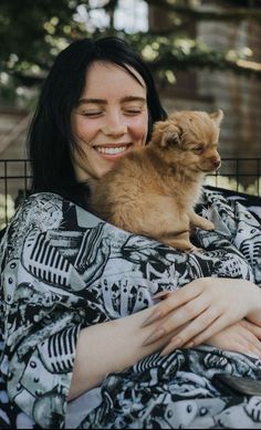 a woman holding a small dog in her arms