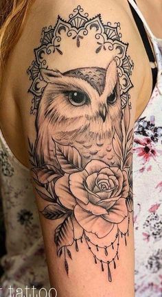 an owl and rose tattoo on the arm