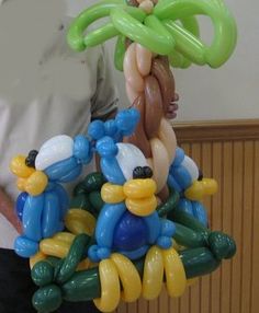 a man standing next to a bunch of balloons in the shape of cartoon character characters