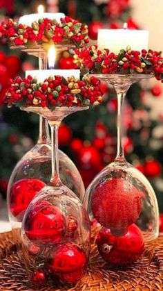 two wine glasses filled with red berries and candles