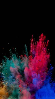 colorful powder is thrown into the air on a black background