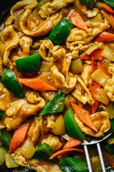 chicken and vegetable stir fry in a wok with tongs on the side, ready to be eaten