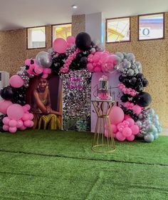 an entrance to a party decorated with pink, black and silver balloons