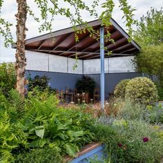 a building with lots of plants and trees around it