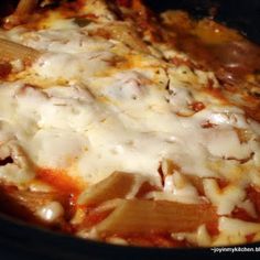 a casserole dish with meat and cheese on top in a slow cooker