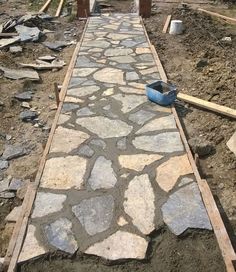 a stone walkway being built in the middle of a field