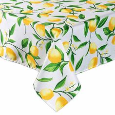 a white table cloth with yellow lemons and green leaves on it, against a white background