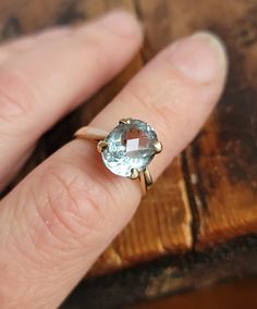 a person's hand with a ring that has an aqua topazte on it