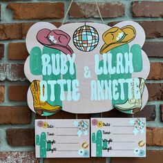 a wooden sign hanging from the side of a brick wall next to another sign that says ruby and julia ottie anette