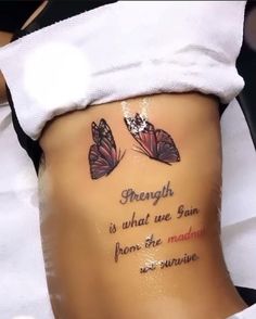 a woman's stomach with two butterflies on it and the words strength is what we gain