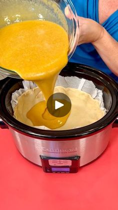 a person pouring orange juice into a crock pot