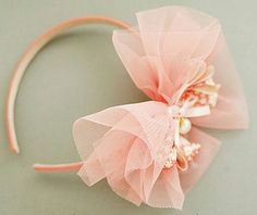 a close up of a pink headband with flowers and pearls on the side,