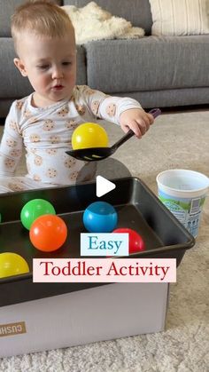 a toddler is playing with an egg tray