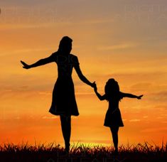 the silhouette of a mother and daughter holding hands as the sun sets in the background