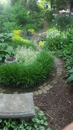 a stone bench sitting in the middle of a garden